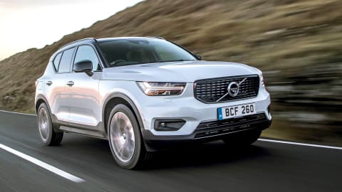 White Volvo XC40 driving down a country road